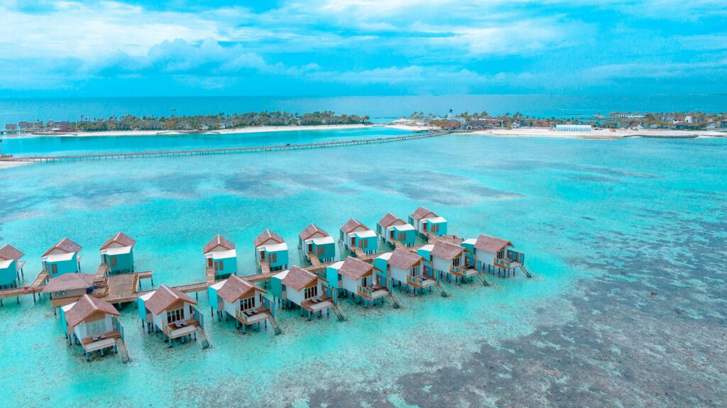 Stunning aerial shot of overwater bungalows on turquoise waters in a tropical island paradise.